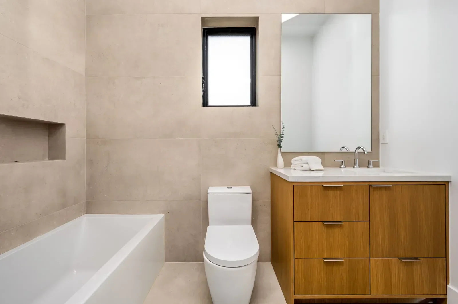 A modern bathroom features a toilet designed to perform well in hard water conditions.