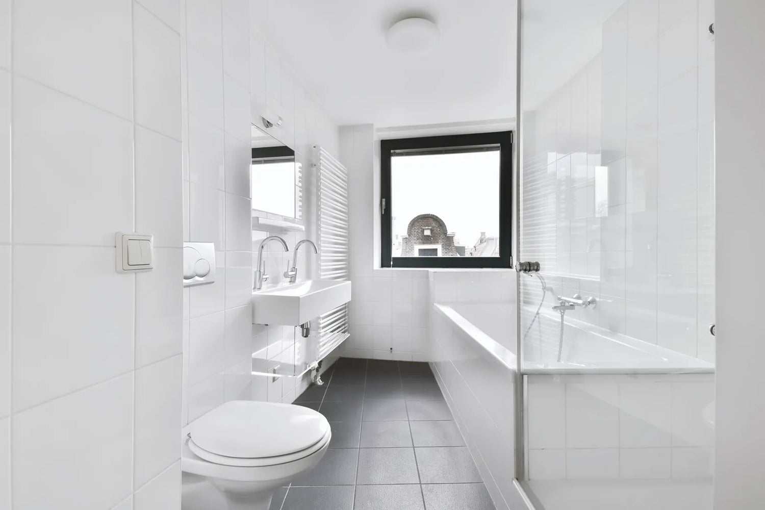 A clean rental bathroom features a simple non-permanent bidet-compatible toilet setup.