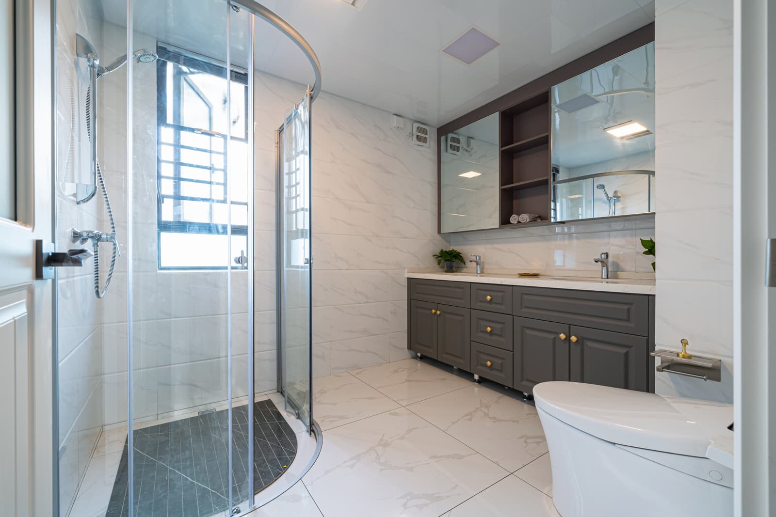 Large contemporary bathroom showcasing a curved inline glass shower enclosure, an alternative straight-line design for wide shower openings.