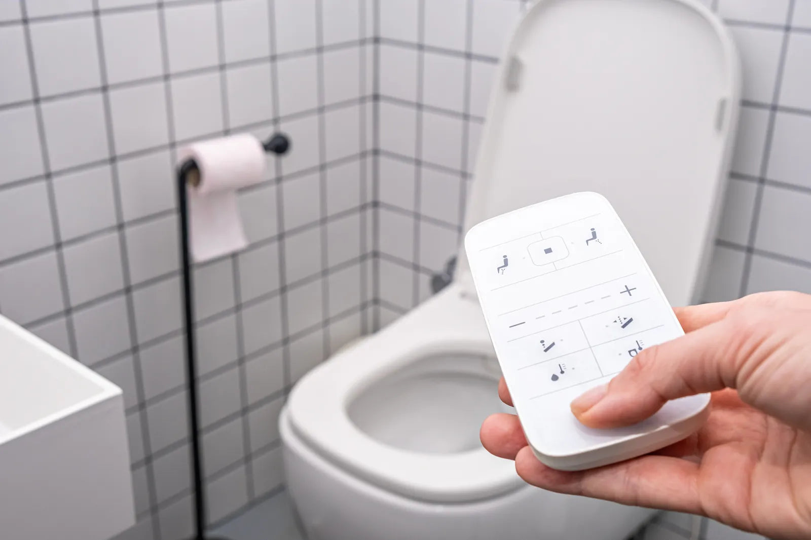 User operating a one-piece smart toilet with a remote control, highlighting its convenient advanced functions.