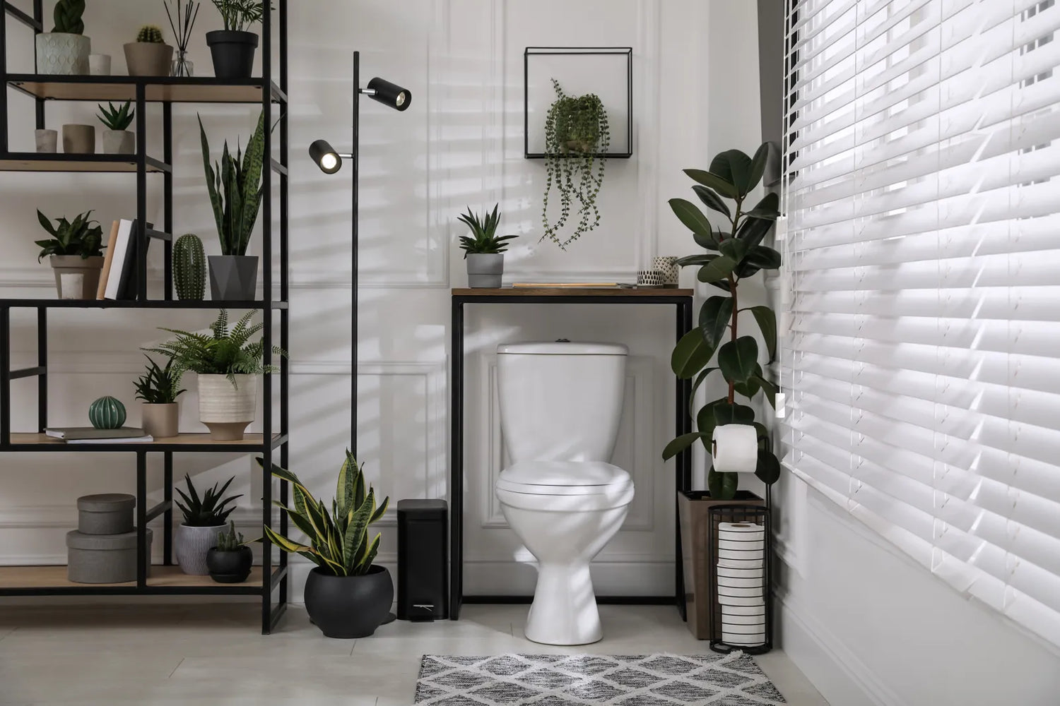 A push button toilet sits in a stylish, plant-filled modern bathroom.