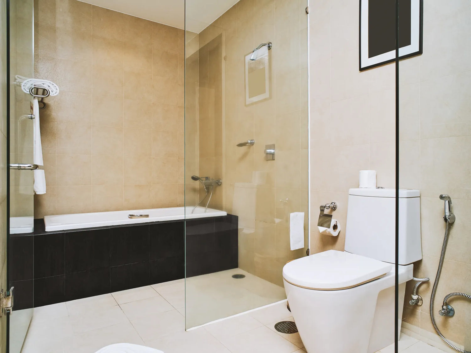 Modern hotel bathroom with glass shower partition, bathtub, and white smart toilet, designed for hygiene and water system sanitization.
