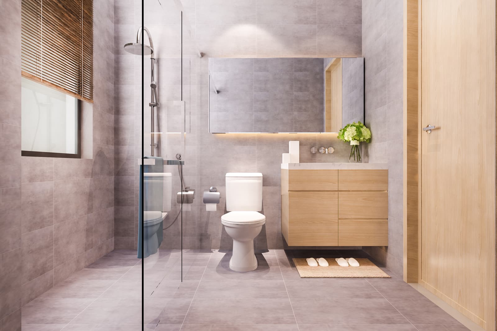 Light-toned contemporary family bathroom featuring a sleek frameless glass shower door, wooden vanity and toilet inside a fully tiled wash space.