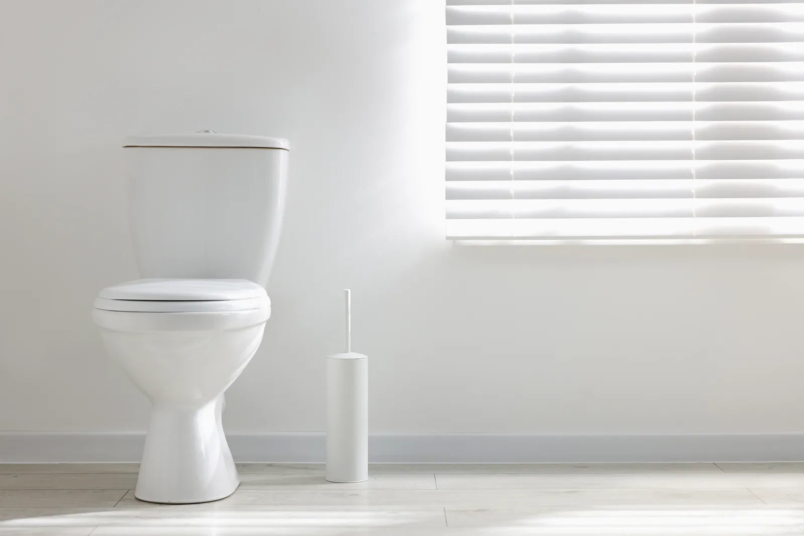 A modern white toilet in a minimalist bathroom, representing the sleek design of contemporary flush technology.