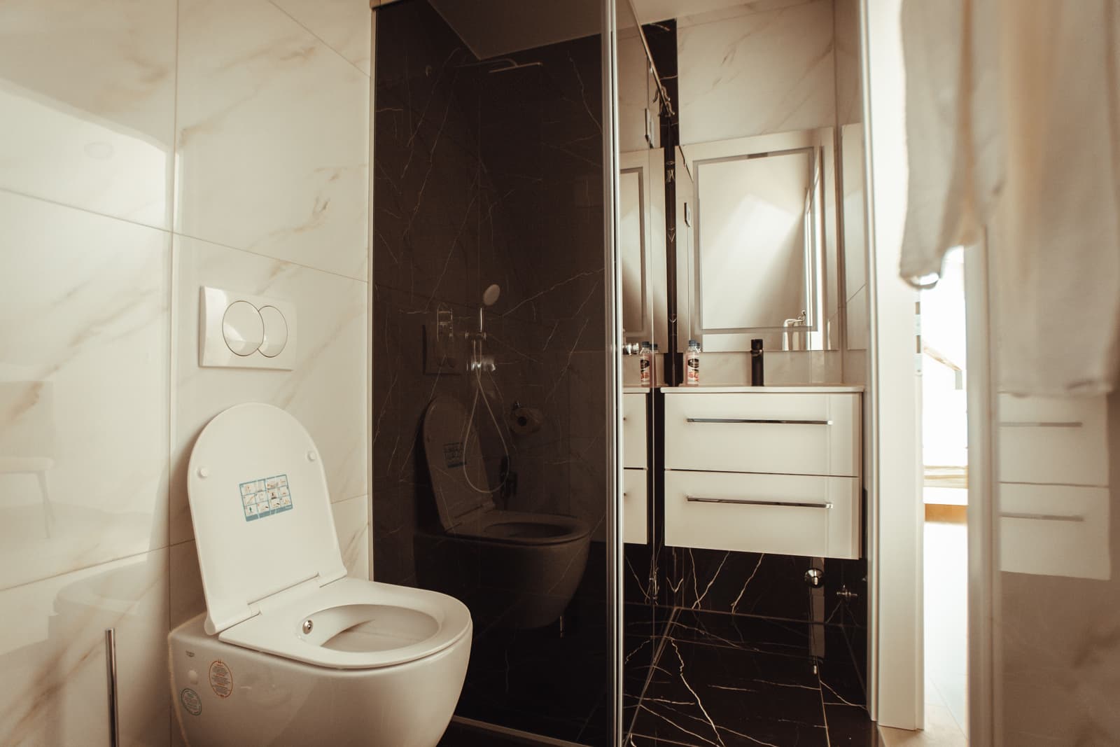 Contemporary white smart toilet installed in a remodeled bathroom, showing a typical fixture retrofit scenario for older house plumbing systems.