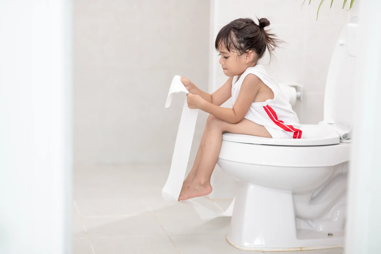 A young child uses a toilet independently, highlighting the importance of smart toilet safety features that ensure comfort, hygiene, and protection in the bathroom.