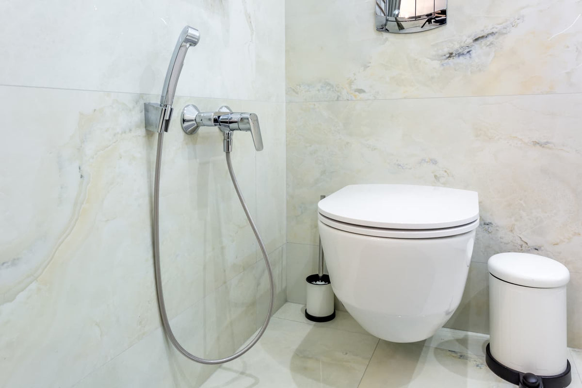 Modern bidet toilet installed in a compact residential guest bathroom