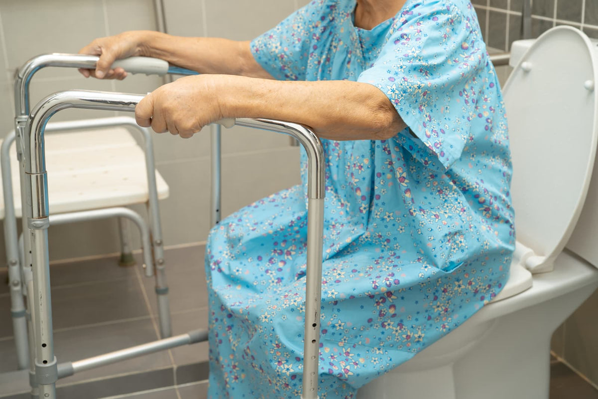 Residential bathroom toilet with clear floor space and a nearby walker