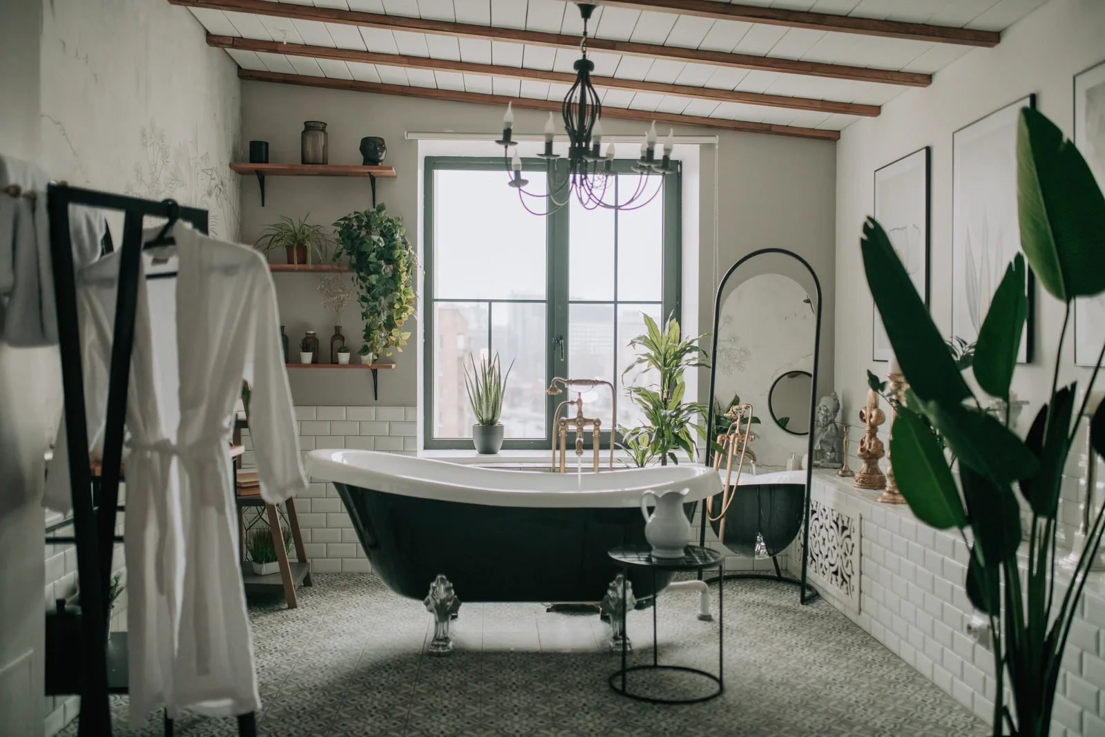 A black and white clawfoot bathtub in a stylish, plant-filled bathroom, creating a luxurious and relaxing spa-like retreat.
