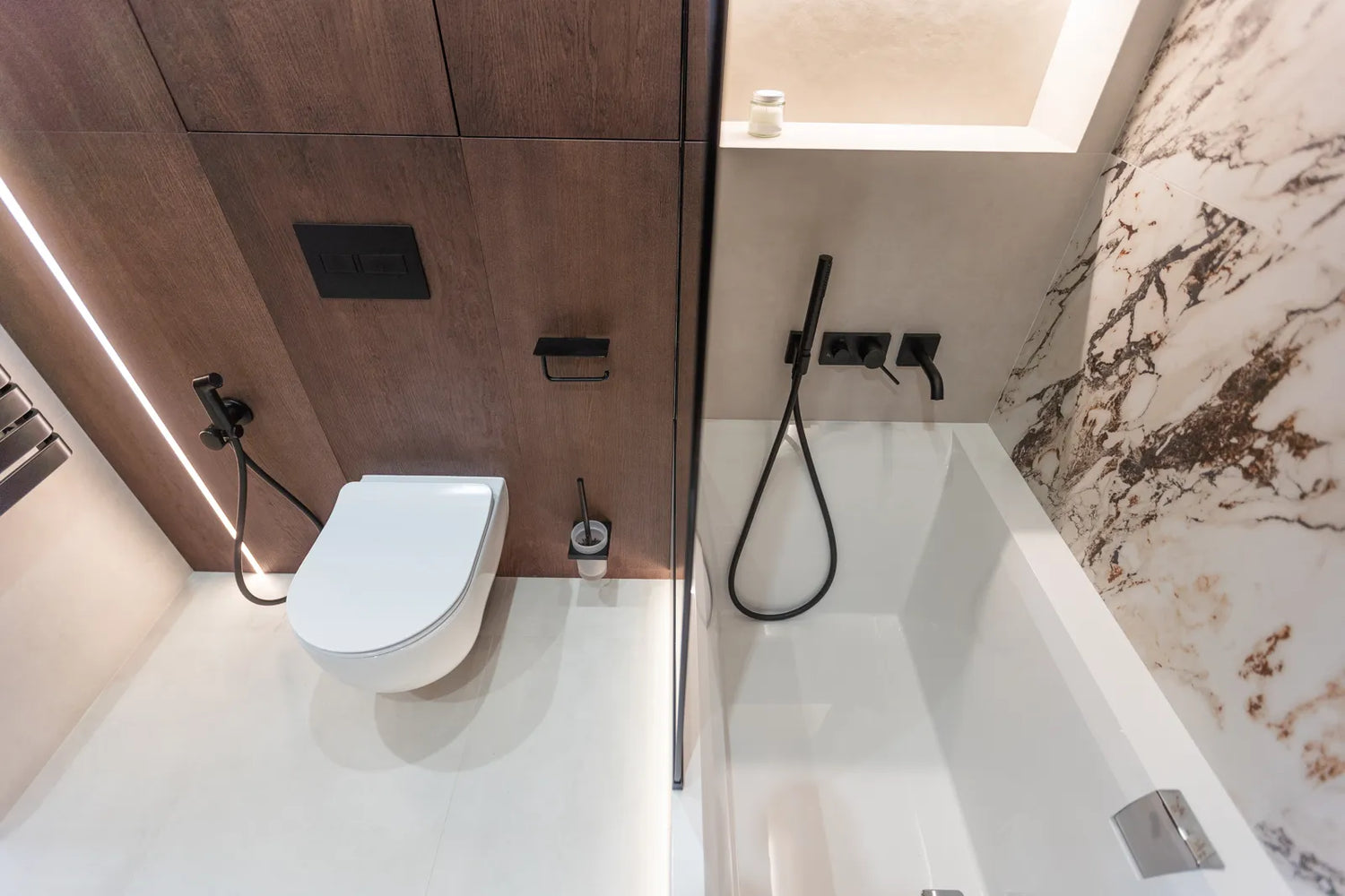 Modern deep soaking tub with ergonomic design, paired with wall-mounted toilet in small bathroom layout.