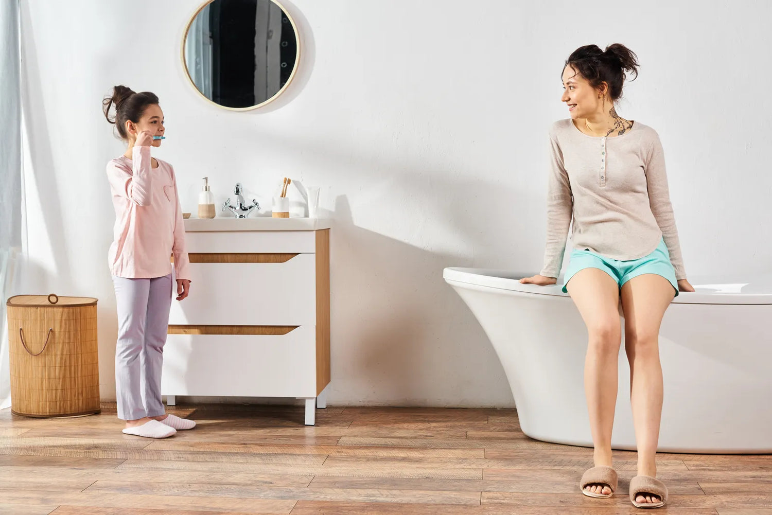 Mother and daughter in a bright, cozy bathroom with a freestanding tub, illustrating a warm, family-friendly upgrade idea.
