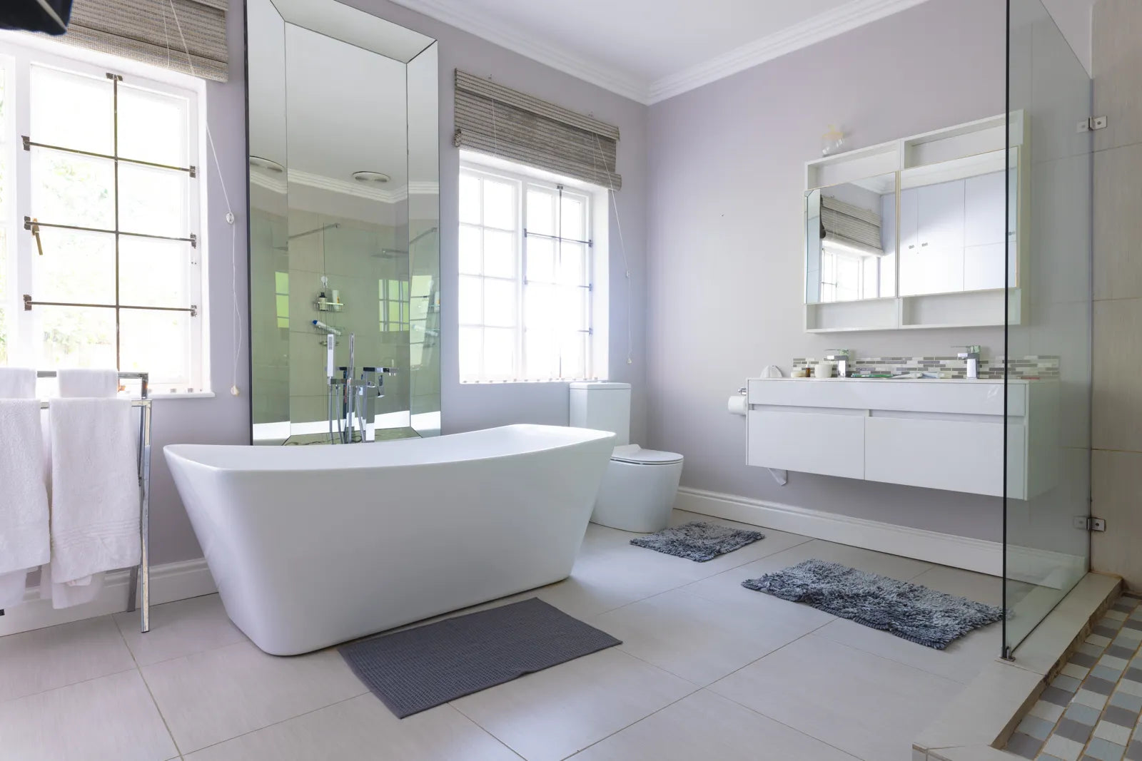 Bright modern bathroom with a sleek oval freestanding tub, perfect for ergonomic solo soaking and soft visual focal points.