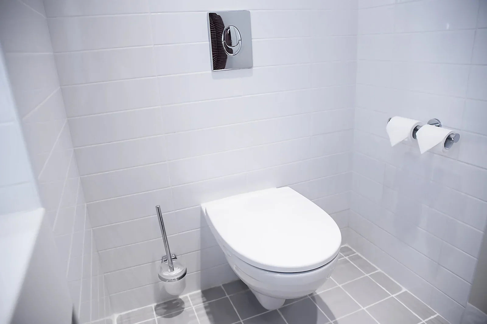 Wall-mounted toilet in a modern bathroom, target for removing hard water stains from toilet.