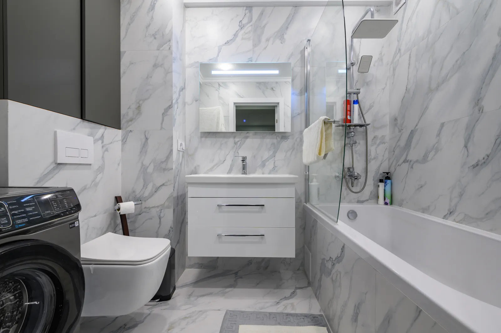 Modern bathroom with a wall-mounted smart toilet, showcasing a finished setup with heated seat and built-in dryer features.