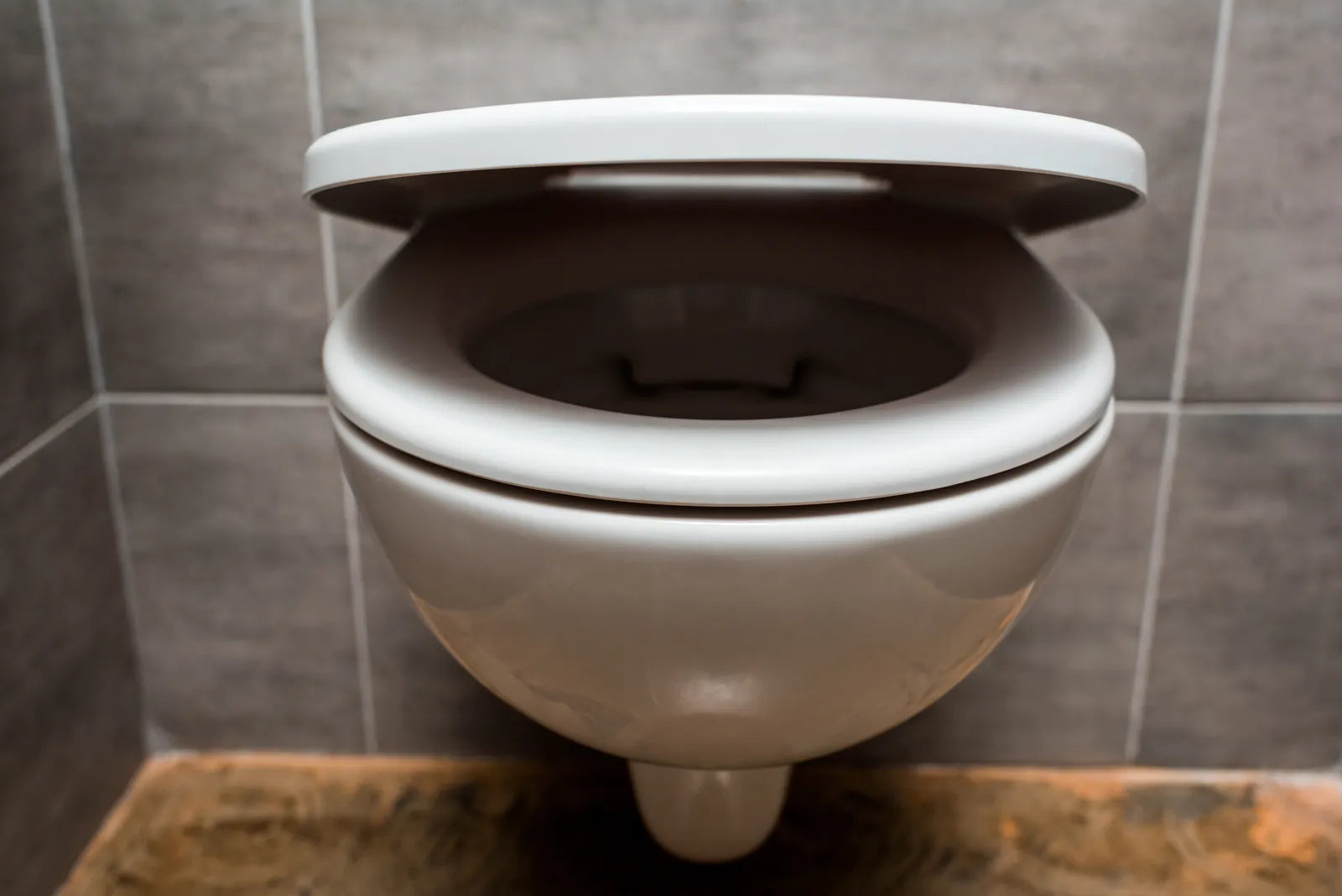 A soft-close toilet seat gently closing in a modern bathroom.