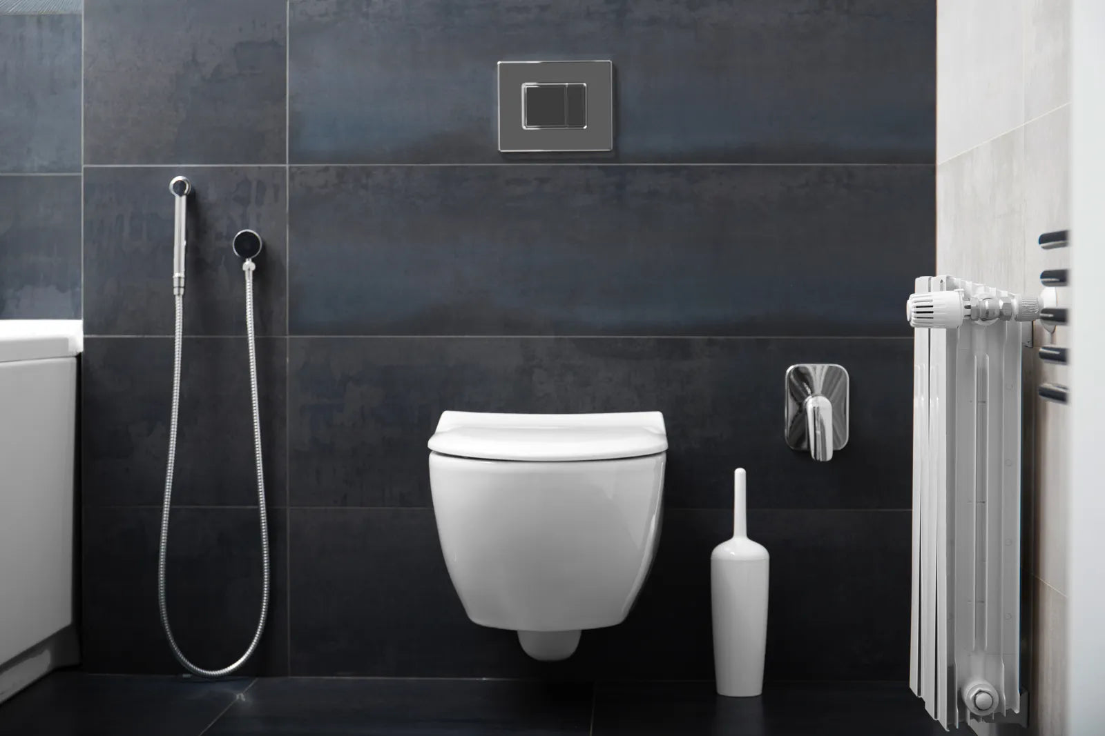 Modern tankless wall-hung toilet in a sleek dark-tiled bathroom, highlighting its clean design.